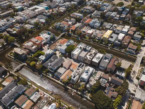 A residential neighborhood with a canal running through it, seen from the air