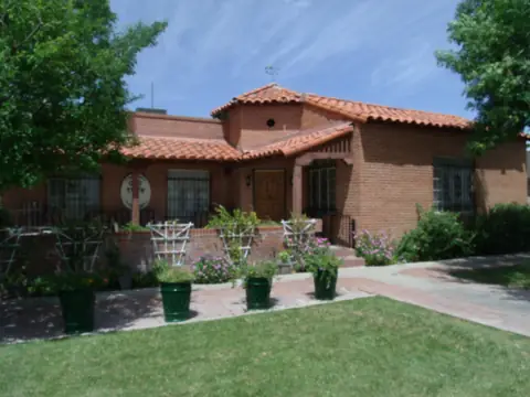A 1949 brick house with a tile roof and lawn in Peoria