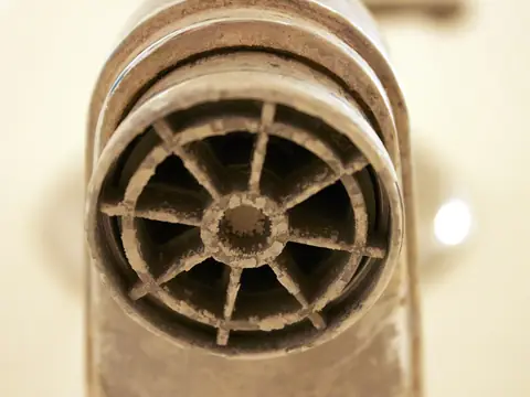 White mineral scale built up inside a faucet aerator