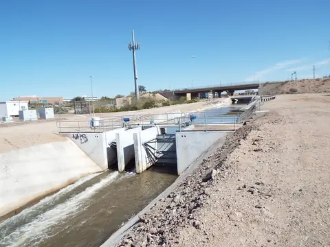 Water running through the gates of the Grand Canal in Phoenix under a blue sky