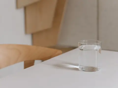 A glass of water on a pale table in daylight