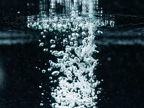 Air bubbles rising through clear water