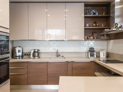 A modern kitchen with pale cabinets and a sink